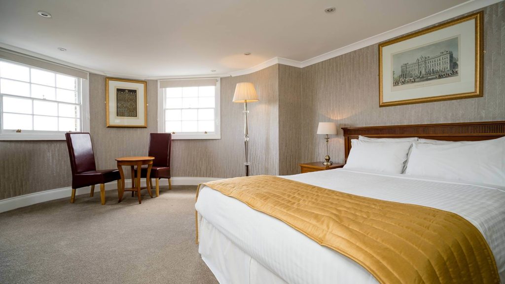 Spacious Clarendon room with cosy bed, elegant furnishings, natural light, perfect for a comfortable stay.