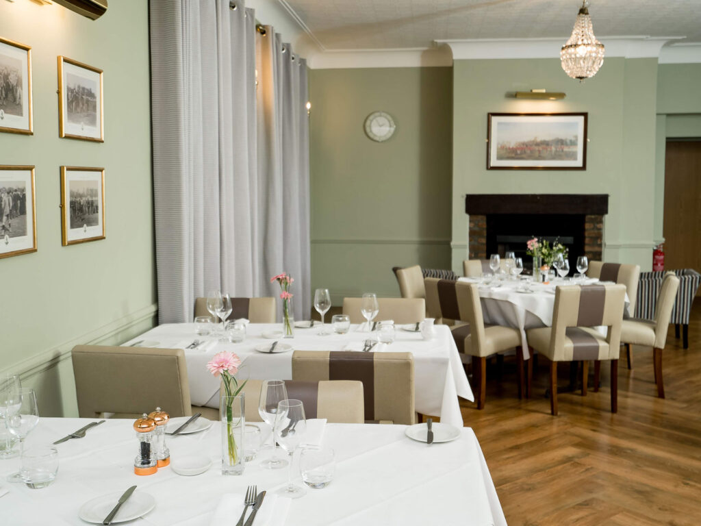 Charming Dining Room at The Clarendon Elegant dining area at The Clarendon with neatly set tables, stylish decor, soft lighting, and exquisite artwork.