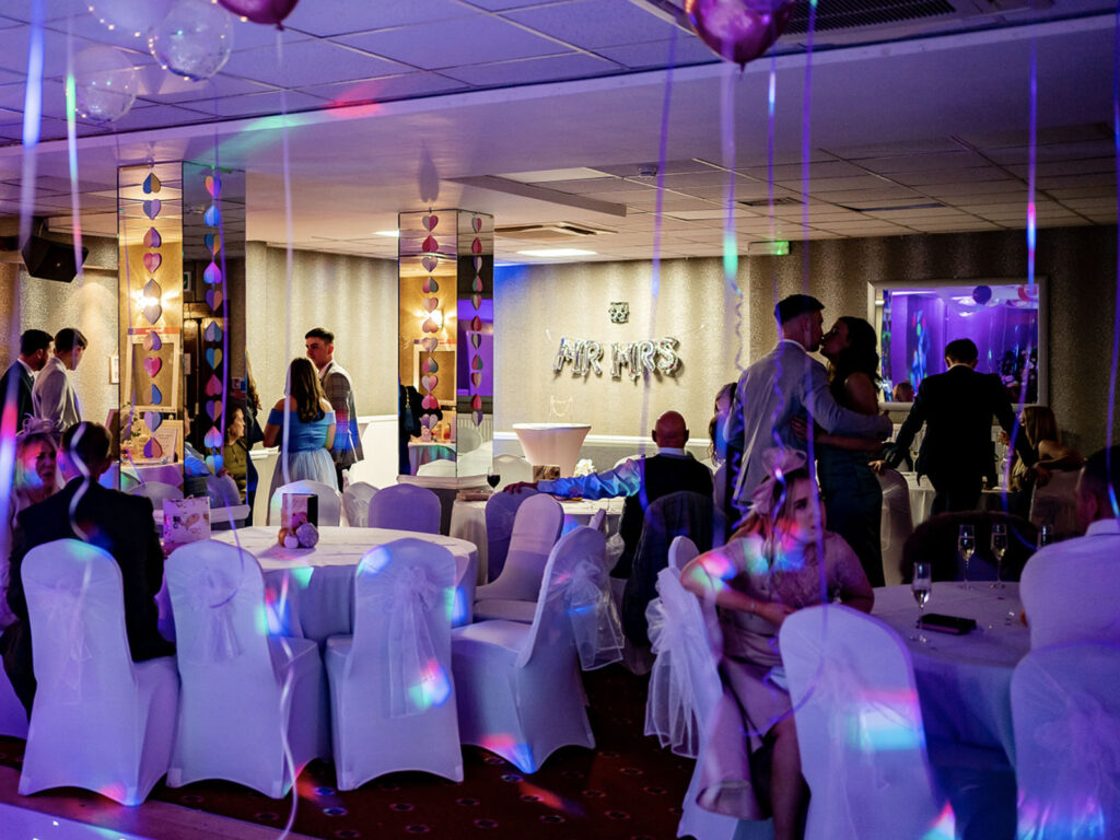 Enchanting Ballroom Celebration Elegant hotel ballroom set for a joyous celebration with guests, charming décor, and ambient lighting at The Clarendon.