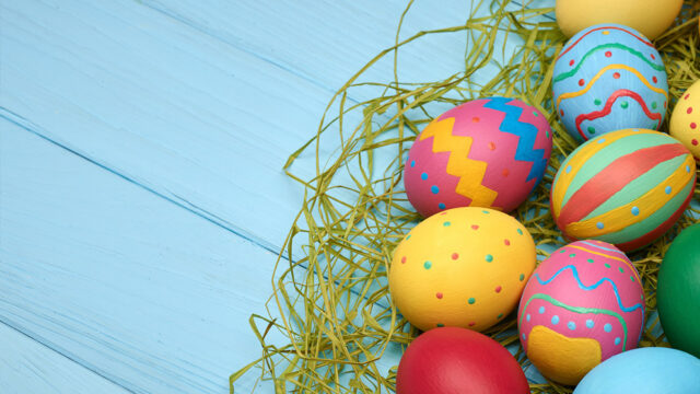 Colourful Easter eggs on a blue wooden table at The Clarendon, creating a vibrant and festive atmosphere.