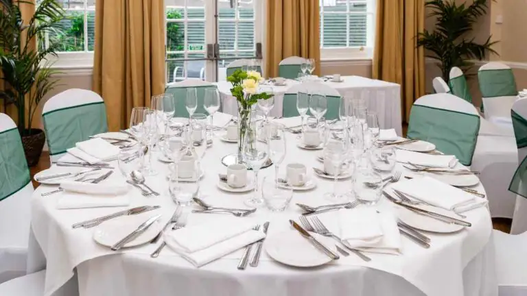 Elegant dining setup at The Clarendon: round table with fine china, chic mint chairs, ideal for events. Bright, welcoming venue.