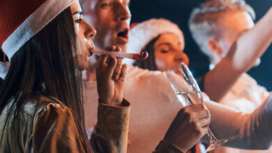 Festive guests at The Clarendon enjoy a joyous Christmas party with champagne, wearing Santa hats, and celebrating together.