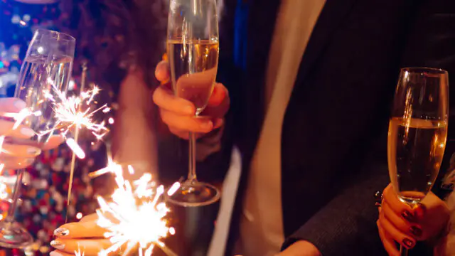 Guests enjoying a lively celebration at The Clarendon, toasting with champagne and sparklers in an elegant setting.