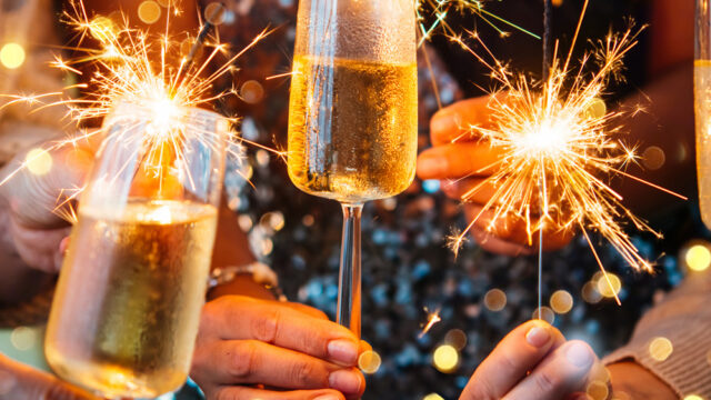 Guests celebrating with sparklers and champagne flutes at The Clarendon. Experience festive elegance and luxury dining.