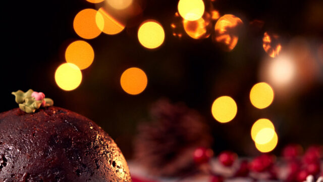 Rich Christmas pudding elegantly served at The Clarendon, with warm festive lights, promising a cosy holiday dining experience.