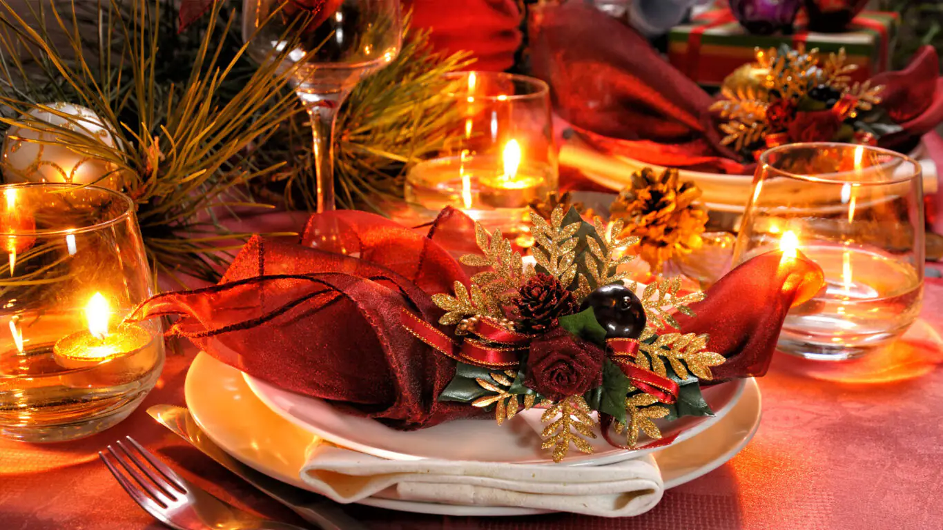 Festive dining setup with elegant red decor and candlelight at The Clarendon Hotel, creating a warm and inviting atmosphere.