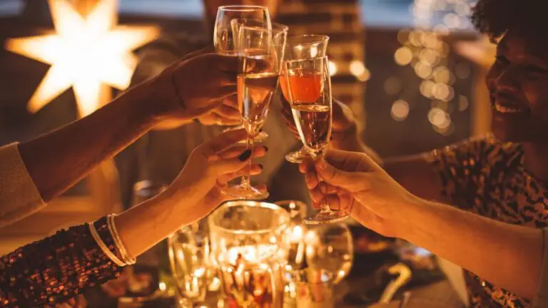 Guests at The Clarendon toast with champagne, enjoying warm, festive dining under soft candlelight, perfect for celebrations.